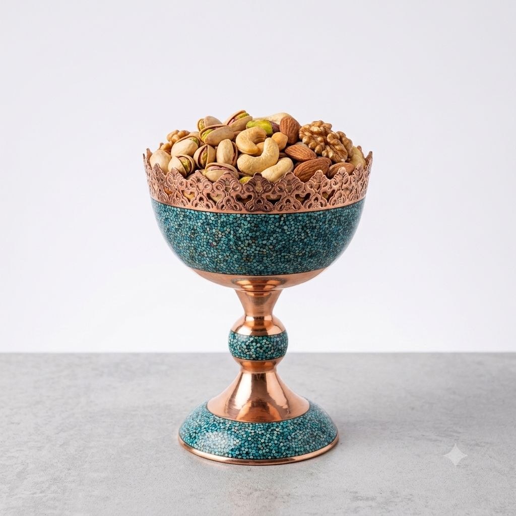 Handcrafted turquoise inlaid copper nut bowl filled with nuts on a marble tabletop.