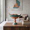 Handmade turquoise inlaying Kashkool dish on a wooden console table with design books.