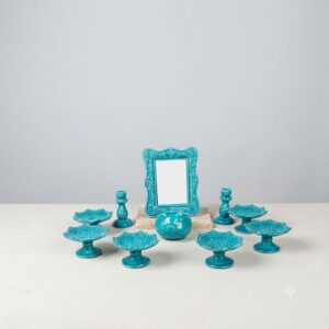 Studio display of 10-piece turquoise Hamedan enamel pottery Haft-sin collection on light background.