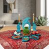 Handcrafted turquoise enamel pottery Haft-sin set on a red Persian woven tablecloth.