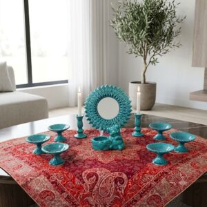 Turquoise enamel Sun Haft-sin set on a rich red paisley cloth.