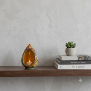 Persian enamel candlestick holder displayed on a dark wood bookshelf alongside art books.