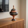 Hand-painted Copper and Pardaz candy dish standing on a modern wooden sideboard.