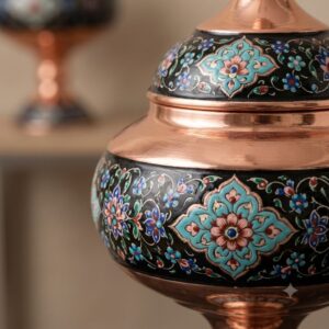 Macro close-up of intricate hand-painted floral Pardaz motifs on polished copper.