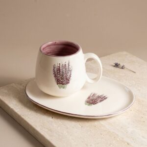 Close-up of handmade lavender ceramic mug highlighting the painted purple stem and glazed rim.