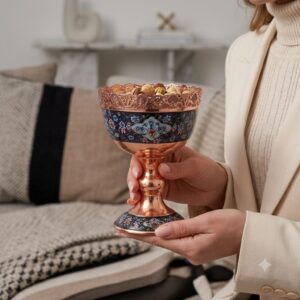 Woman holding a Persian Copper and Pardaz goblet bowl showing intricate hand-painted floral motifs.
