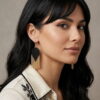 Woman wearing handmade black and gold-toned beaded drop fringe earrings.
