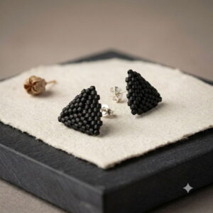 Studio flat shot of matte black triangle beaded stud earrings showing secure metallic post backs.