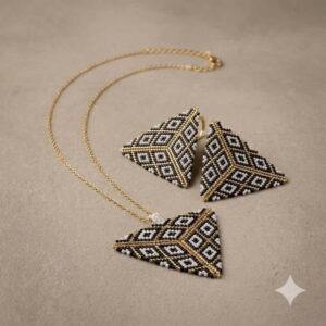 A modern woman wearing a matching 3D geometric pyramid necklace and drop earrings styled with a silk cream blouse.