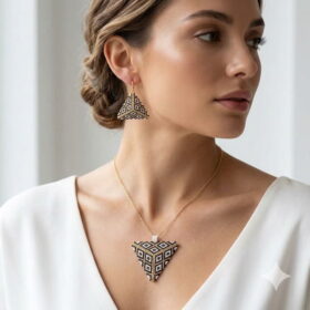 A model wearing the sophisticated black and gold-colored accent geometric bead jewelry set with an elegant updo.