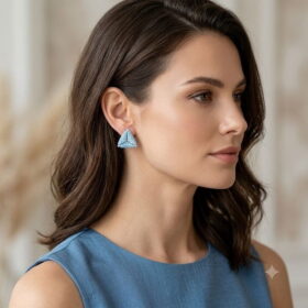 Woman wearing light blue 3D beaded triangle stud earrings in side profile.