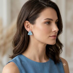 Woman wearing light blue 3D beaded triangle stud earrings in side profile.