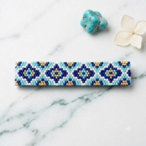 Flat lay photo of the blue mosaic pattern beaded bracelet on white marble with turquoise stone.