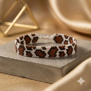 Close-up view of the luxury cow pattern artisan bracelet highlighting the intricate metallic gold-finish seed beads.