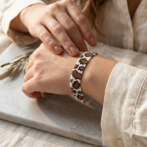 A side-angle lifestyle photo emphasizing the lightweight comfort and fluid drape of the handmade beaded cuff.