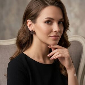 Model posing with luxury handmade gold-toned beaded geometric triangle stud earring.