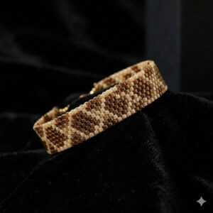 A detailed shot of the intricate texture on a brown geometric seed bead bracelet resting on black velvet.