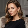 Elegant woman wearing gold-toned 3D beaded triangle stud earrings with a black dress.