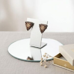3D woven artisan triangle earrings displayed on a silver jewelry stand.