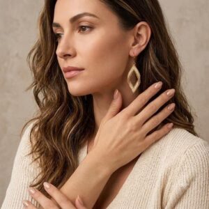 Model wearing hand-woven gold-toned 3D diamond drop statement earring.