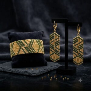 Luxury display of green and gold-toned beaded cuff on black velvet pillow with earrings.