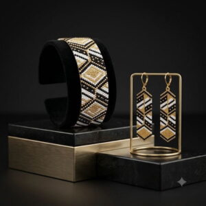 Gold-finish geometric beaded cuff and dangle earrings set on black marble pedestal display.