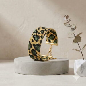 Side angle of a green leopard print beaded bracelet showing the adjustable gold-colored clasp and chain.