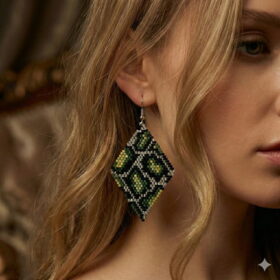 Close-up of a woman wearing a handmade green and gold-toned rhombus pattern bead earring.