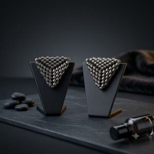 Gunmetal triangle beaded stud earrings on matte black display stands with slate base.