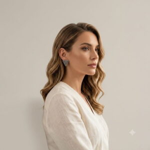 Blonde model in white linen blazer wearing gunmetal woven triangle stud earrings.