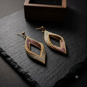 Mauve Diamond Beaded Statement Earrings on a black slate tray next to a wooden jewelry box.
