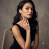 Dark-haired woman wearing black 3D gold-toned beaded diamond earrings with black top.