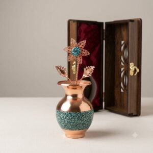 Handmade turquoise copper vase and flower standing next to its carved wooden gift box.