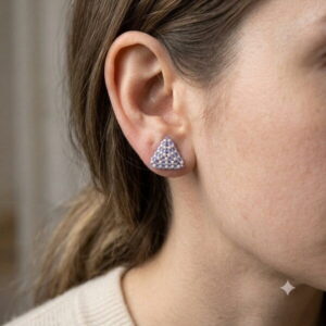Macro close-up of model earlobe showing fit of periwinkle woven triangle stud earring.