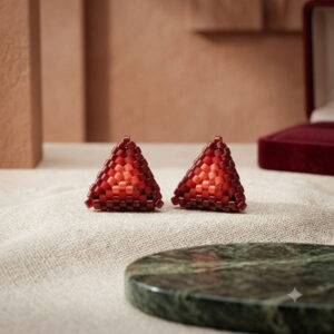 Artisan handmade 3D red woven triangle earrings on beige linen surface.