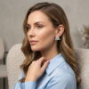 Model wearing a 3D hand-woven silver beaded triangle earring with a blue shirt.