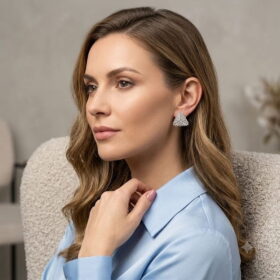 Model wearing a 3D hand-woven silver beaded triangle earring with a blue shirt.