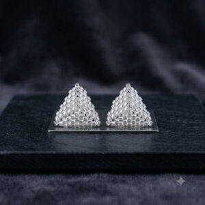Pair of hand-woven silver 3D triangle beaded stud earrings displayed on slate.