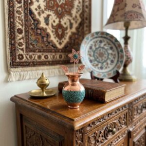 Handcrafted copper flower and turquoise inlay mini vase displayed on a vintage carved wooden cabinet.
